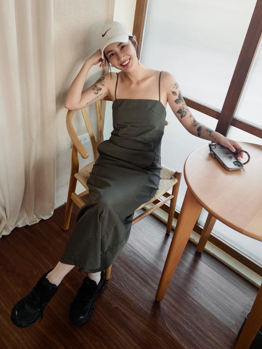 ブラック系のスニーカー、ベージュ系のキャップを着用したレディースの春コーディネートの2枚目の写真