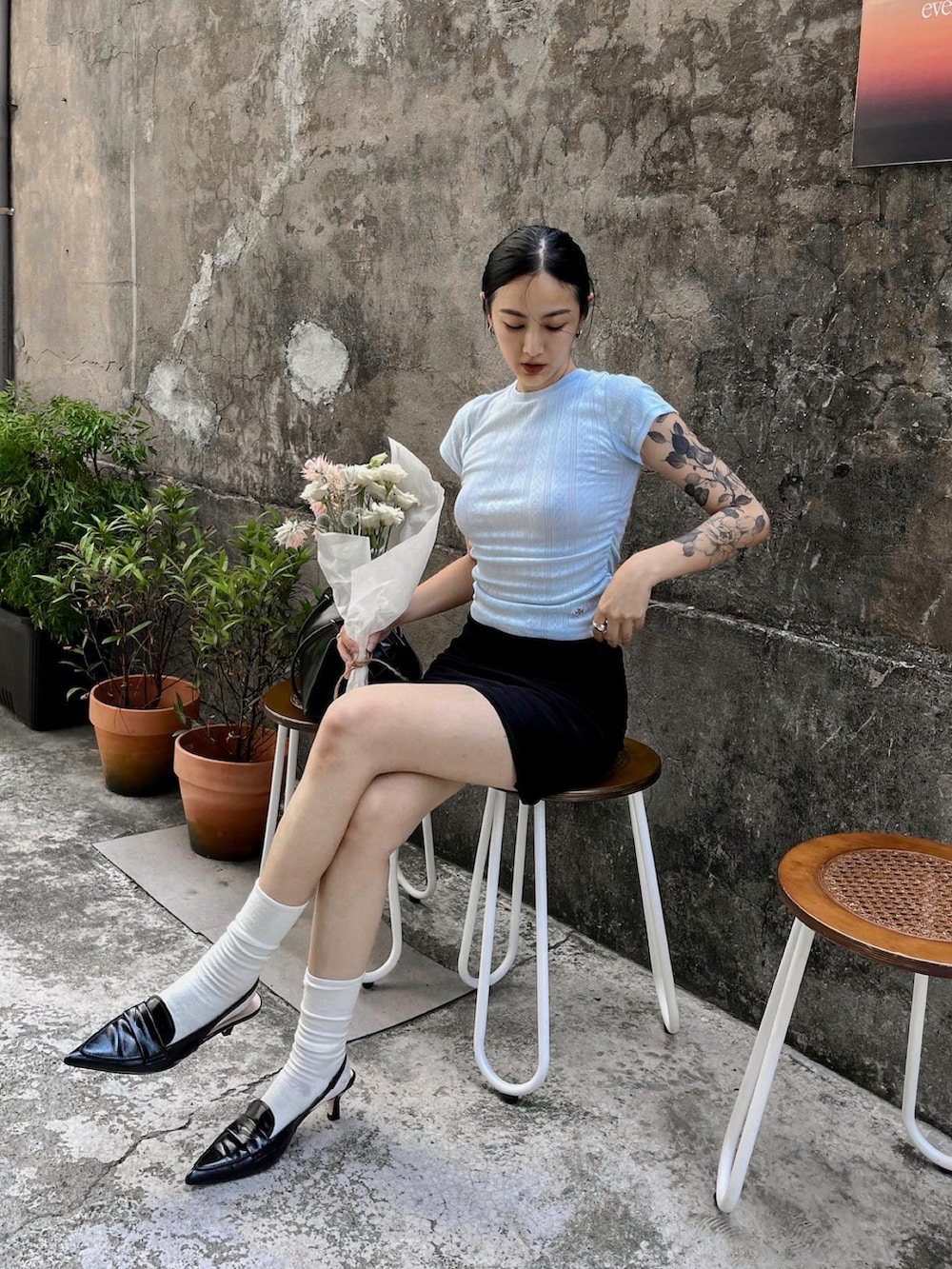 ブルー系のトップスを着用したレディースの夏コーディネートの2枚目の写真