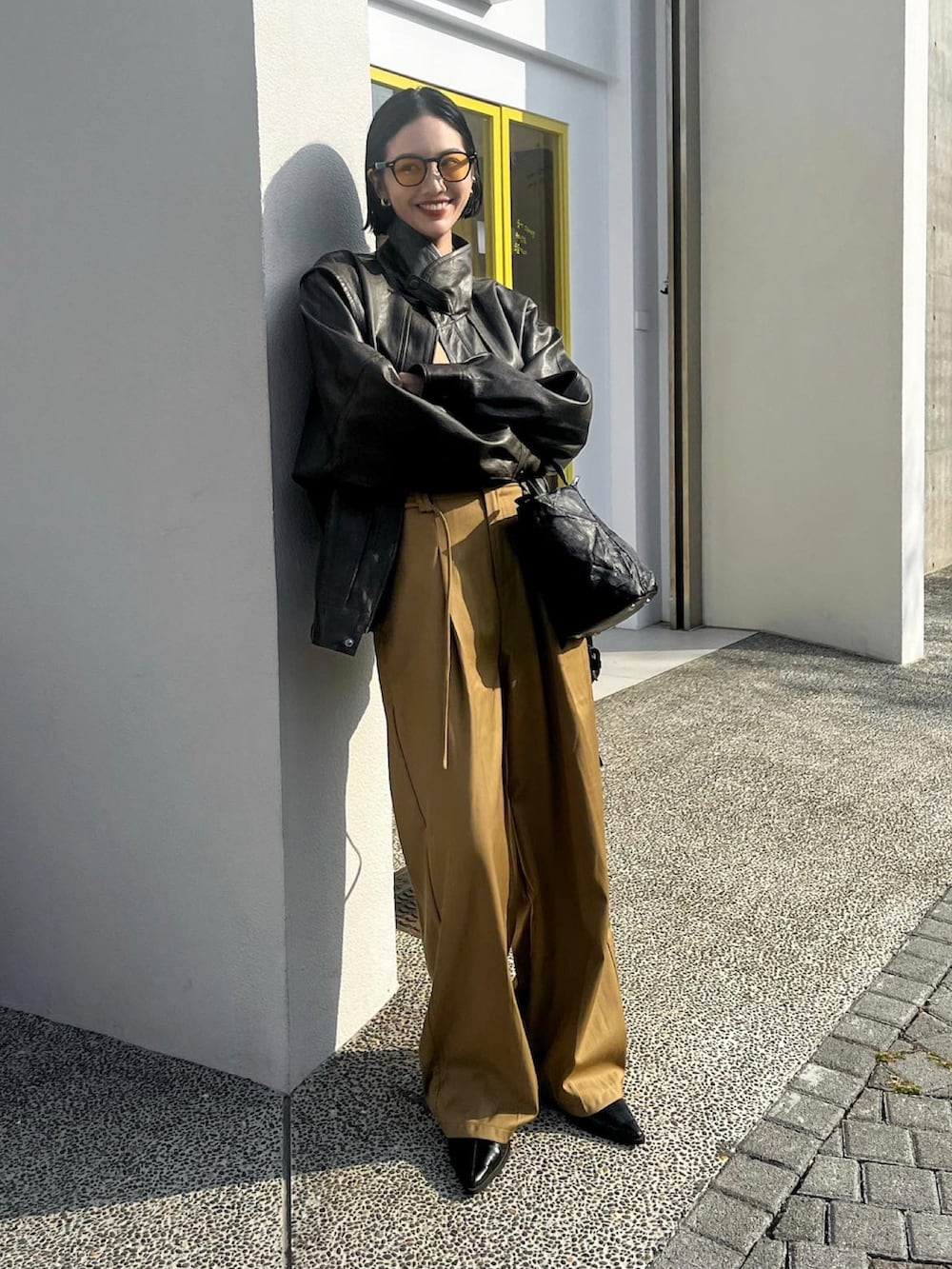 ブラウン系のスラックスを着用したレディースの秋コーディネートの2枚目の写真