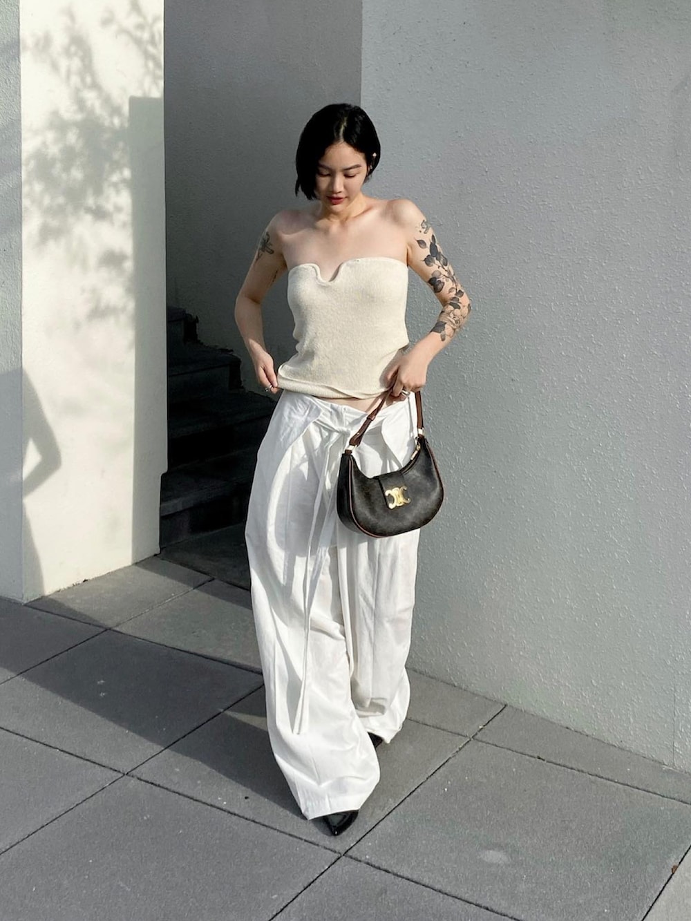 ブラウン系のショルダーバッグを着用したレディースの夏コーディネートの2枚目の写真