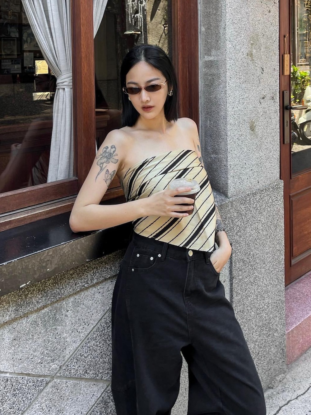 ブラック系のデニムパンツを着用したレディースの夏コーディネートの2枚目の写真