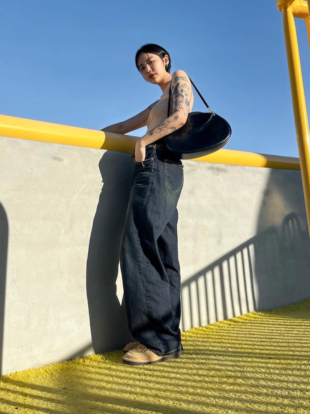 ブラック系のデニムパンツを着用したレディースの夏コーディネートの2枚目の写真