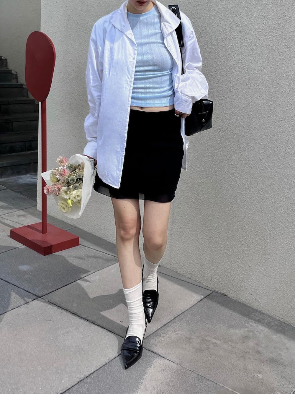 ブルー系のトップスを着用したレディースの夏コーディネートの3枚目の写真