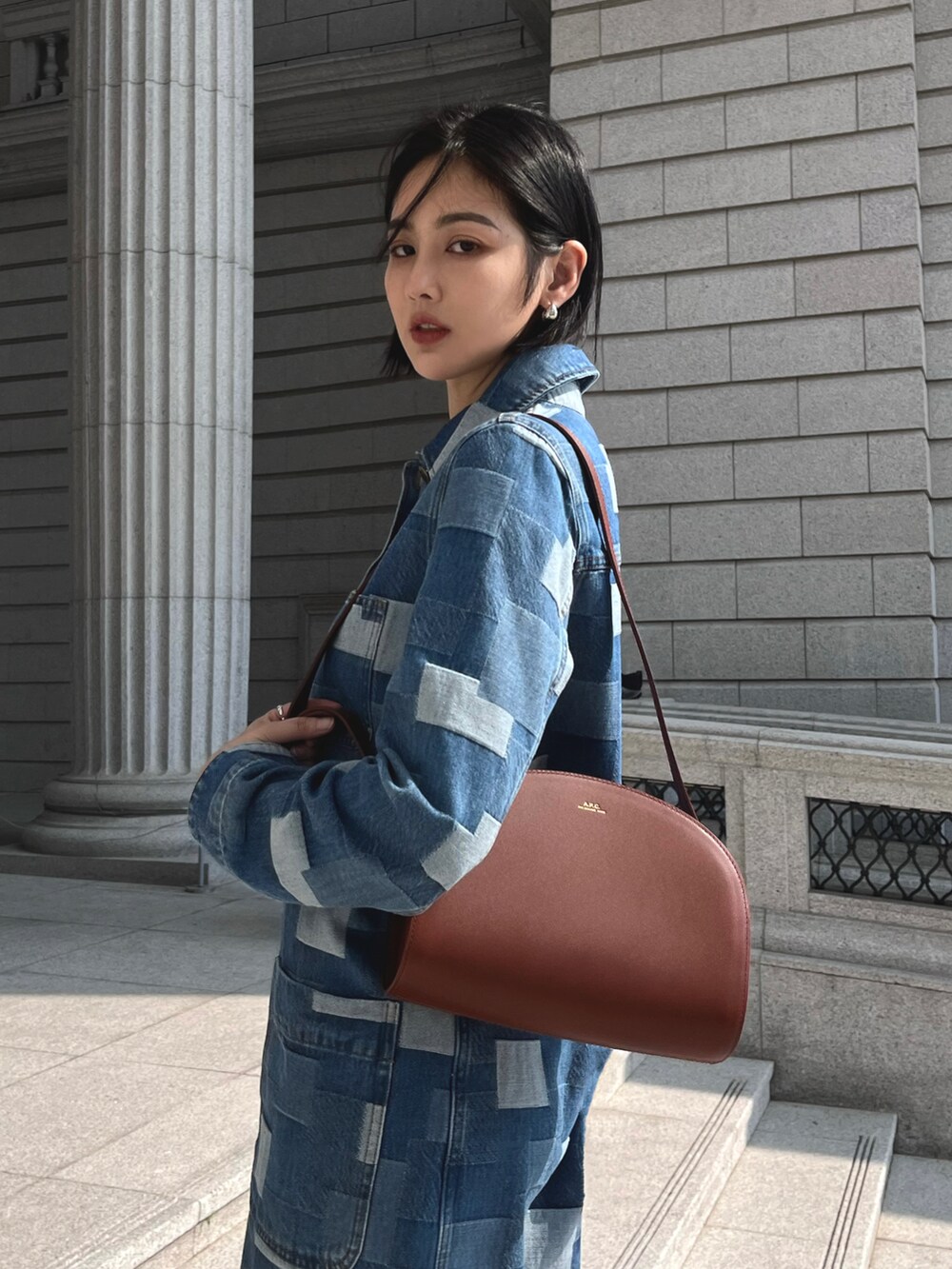 ブラウン系のショルダーバッグを着用したレディースの春コーディネートの2枚目の写真