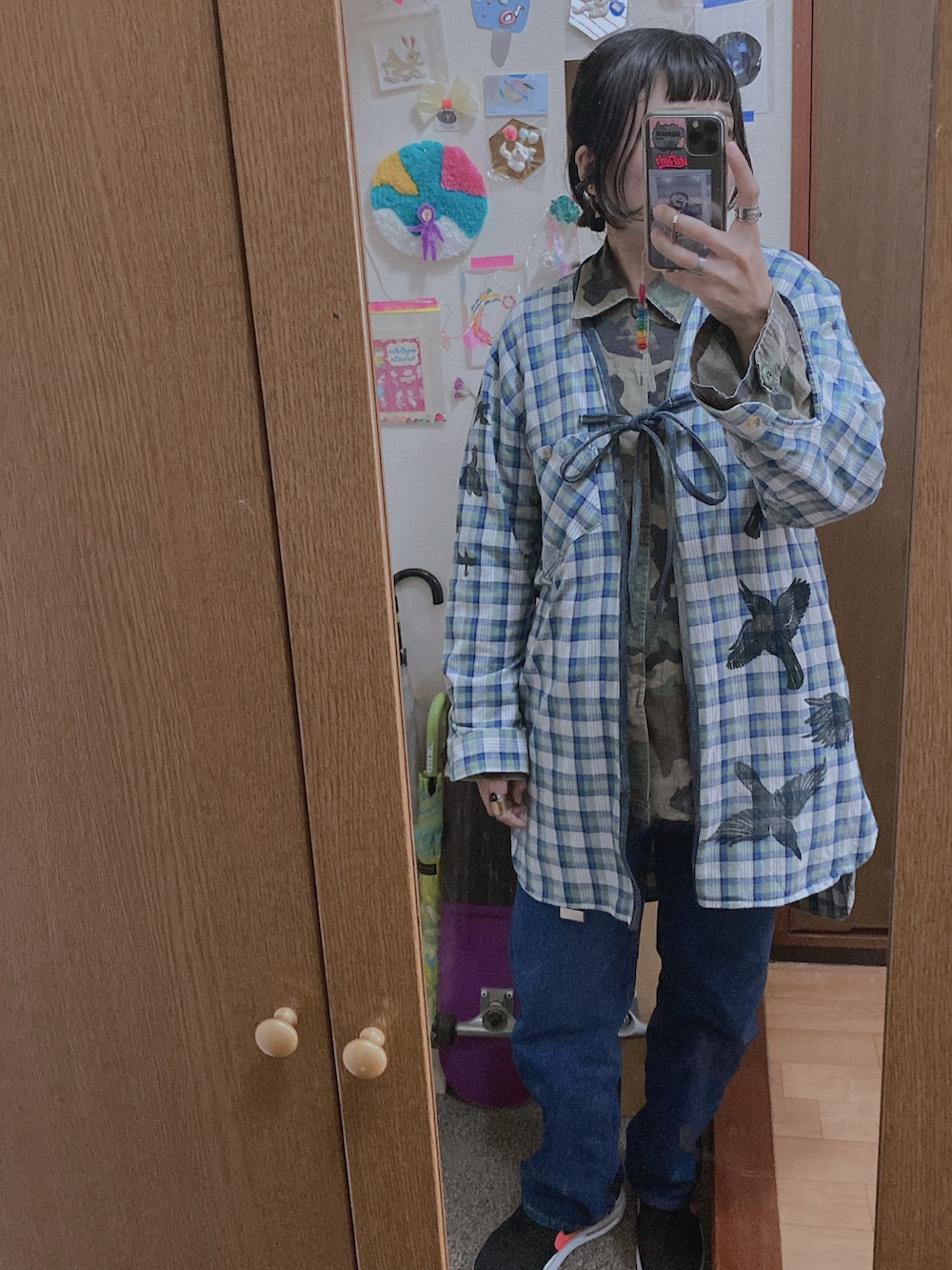 ブルー系のノーカラーコート、グリーン系のミリタリージャケットを着用したレディースの冬コーディネートの2枚目の写真