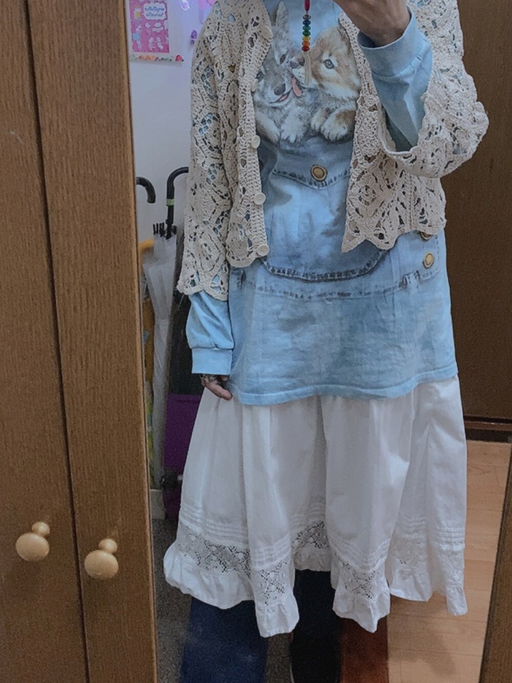 ホワイト系のスカート、ベージュ系のカーディガン/ボレロを着用したレディースの冬コーディネートの2枚目の写真