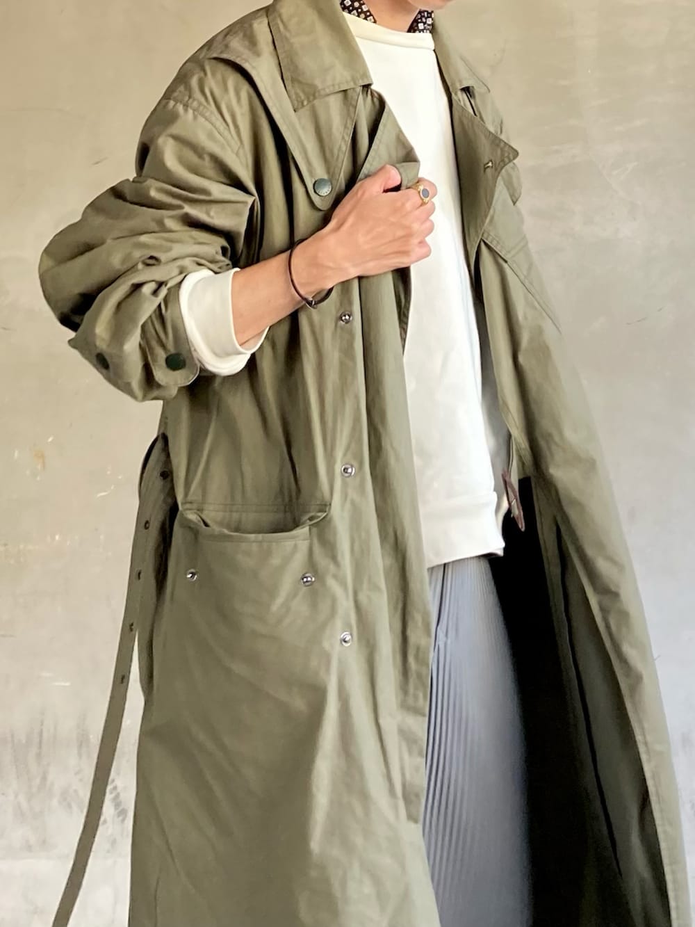 グレー系のパンツ、ホワイト系のスニーカー、ホワイト系のトップスを着用したメンズの春コーディネートの4枚目の写真