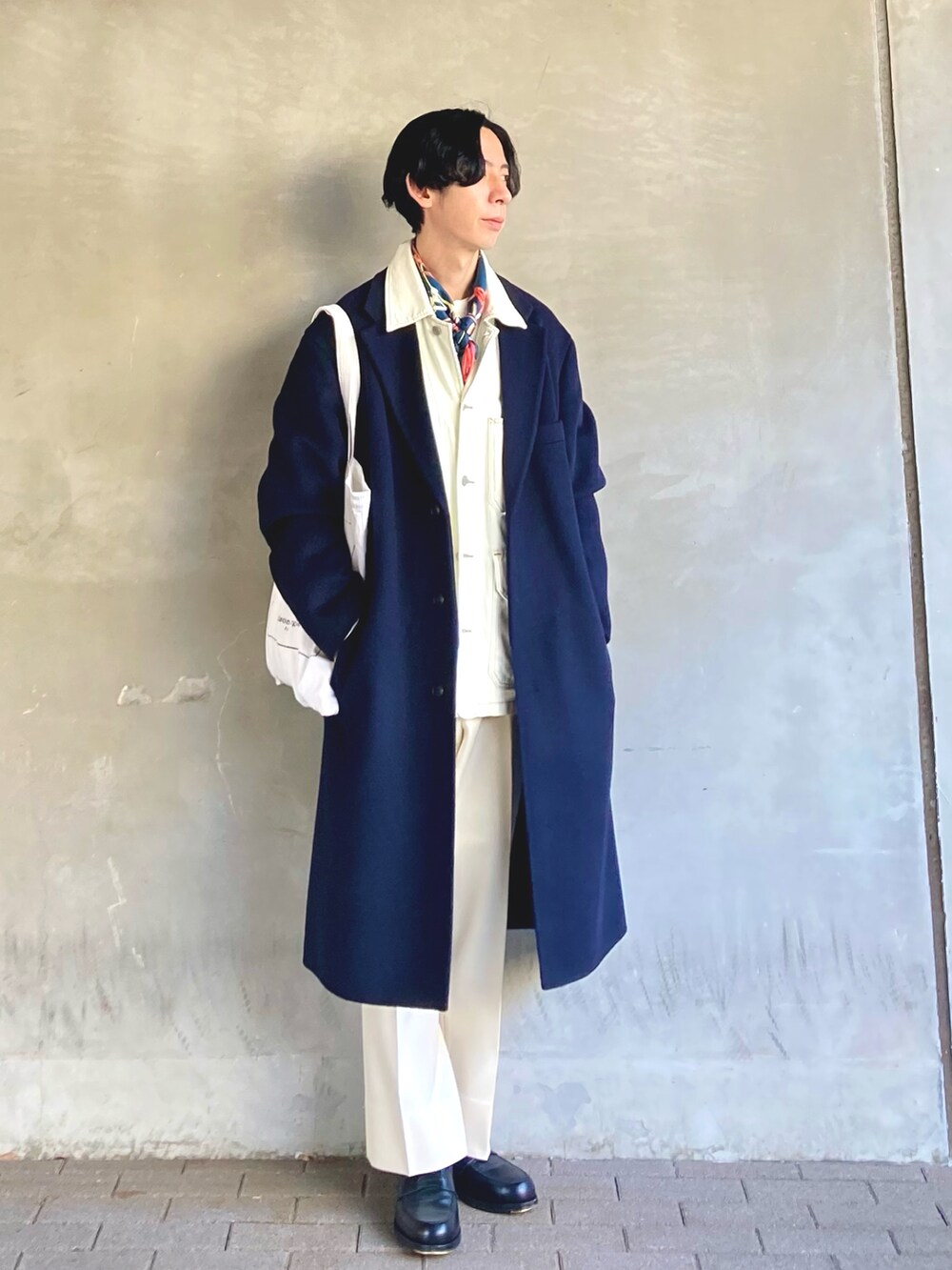 ブラック系のローファー、ホワイト系のトートバッグ、ホワイト系のスラックスを着用したメンズの冬コーディネートの3枚目の写真