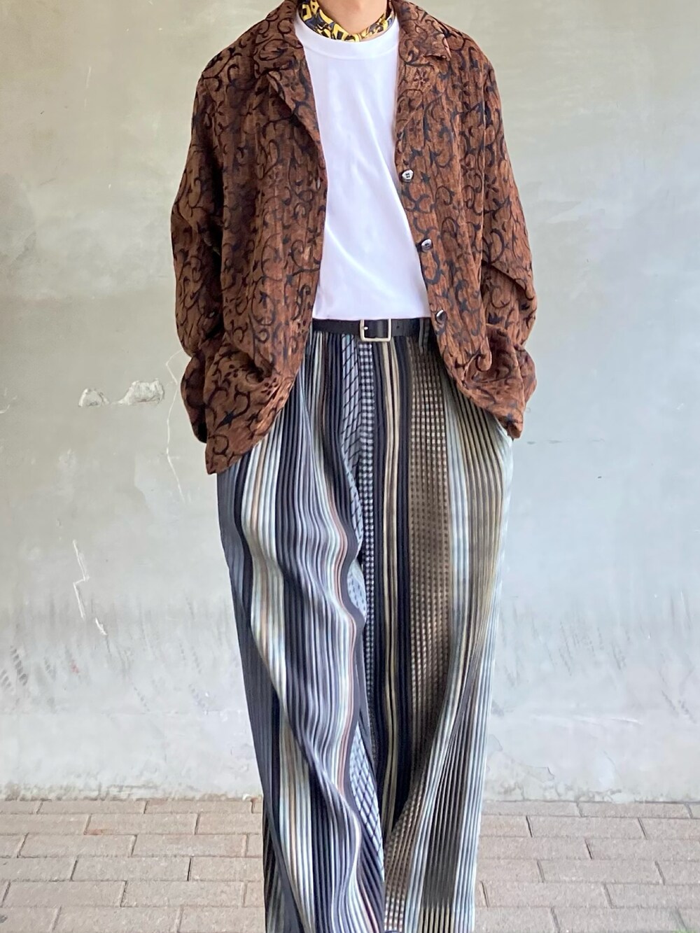 ブラウン系のテーラードジャケット、ホワイト系のTシャツ/カットソー、ベージュ系のパンツを着用したメンズの春コーディネートの2枚目の写真