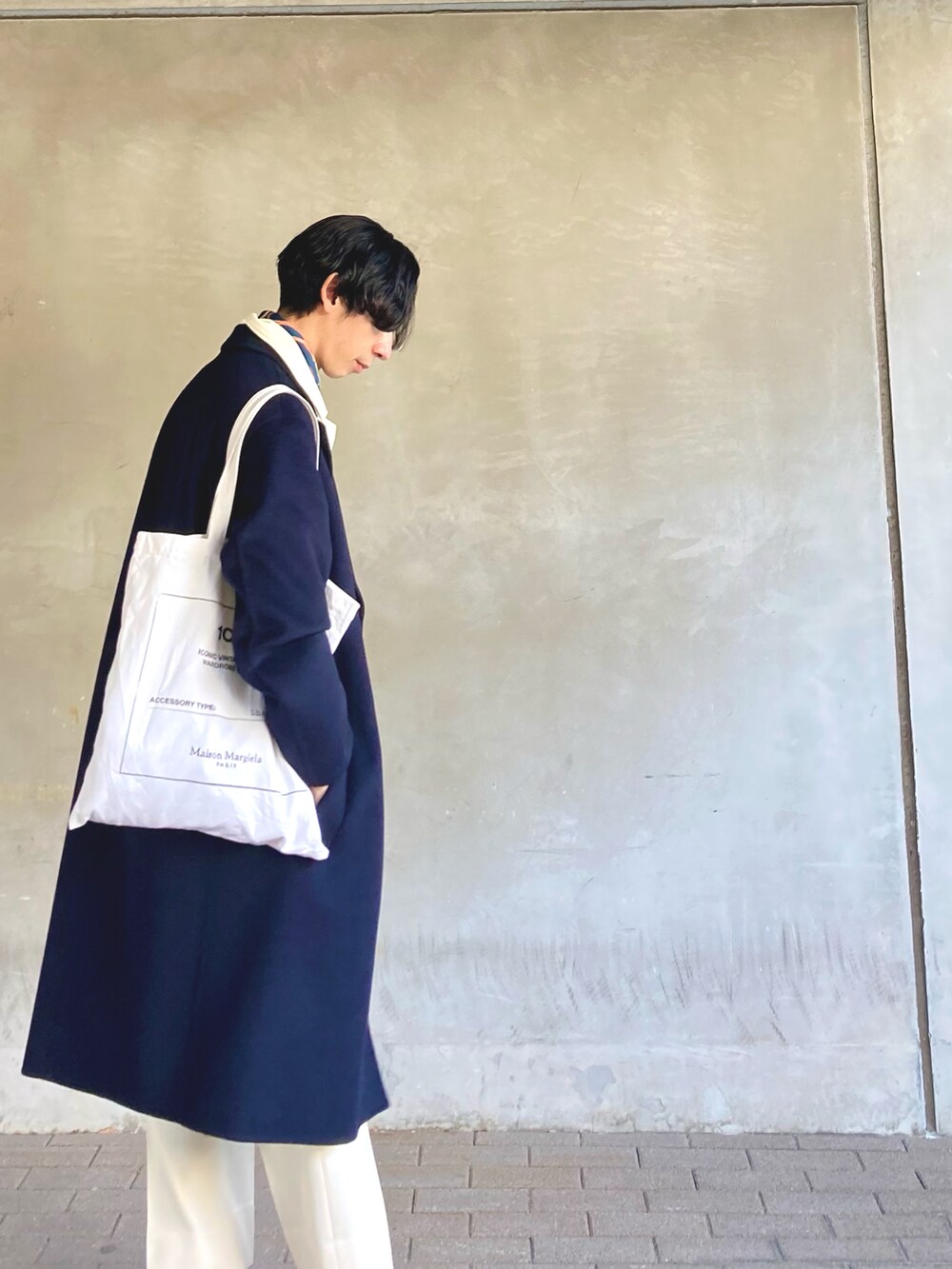 ブラック系のローファー、ホワイト系のトートバッグ、ホワイト系のスラックスを着用したメンズの冬コーディネートの4枚目の写真