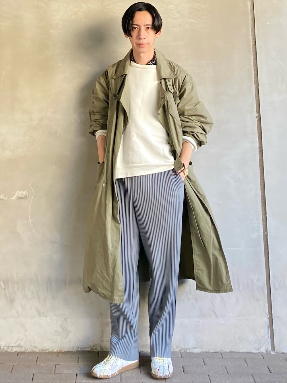 グレー系のパンツ、ホワイト系のスニーカー、ホワイト系のトップスを着用したメンズの春コーディネートの3枚目の写真