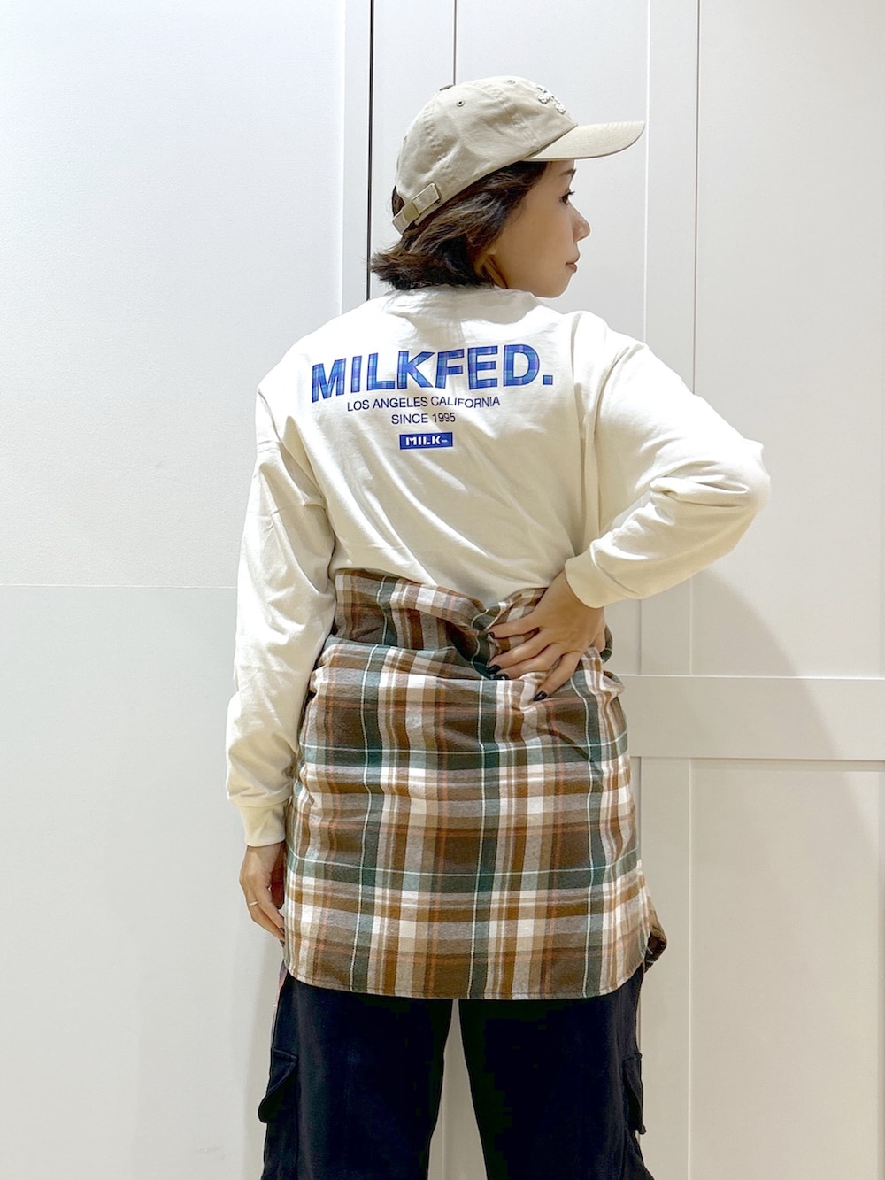 オレンジ系のシャツ/ブラウス、ブラック系のブルゾン、ホワイト系のTシャツ/カットソーを着用したレディースの秋コーディネートの9枚目の写真