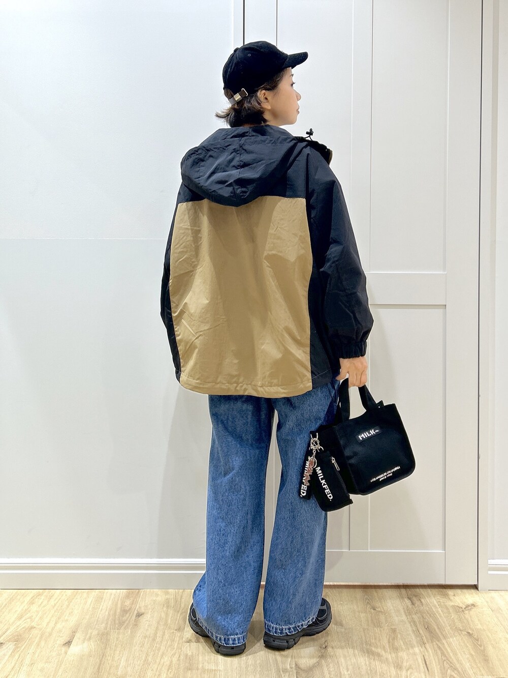 グレー系のTシャツ/カットソー、ベージュ系のマウンテンパーカー、ブルー系のデニムパンツを着用したレディースの秋コーディネートの3枚目の写真