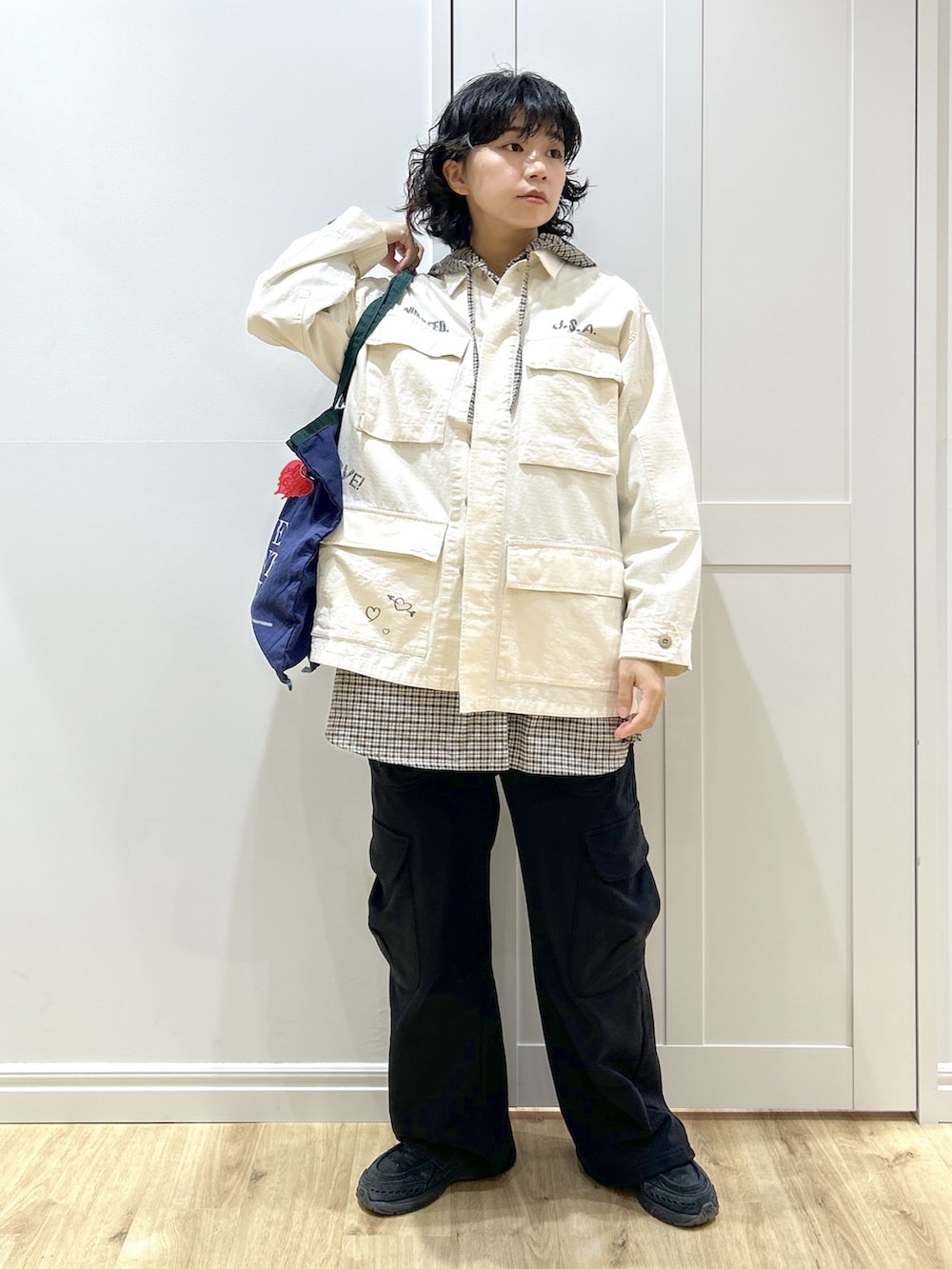 ホワイト系のミリタリージャケット、ベージュ系のシャツ/ブラウス、ブラック系のスウェットパンツを着用したレディースの冬コーディネートの2枚目の写真