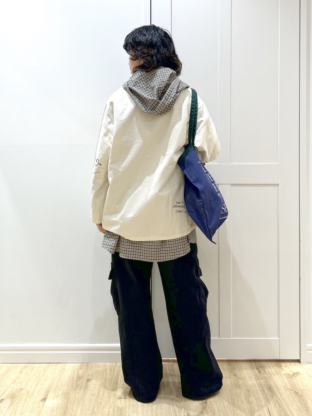 ホワイト系のミリタリージャケット、ベージュ系のシャツ/ブラウス、ブラック系のスウェットパンツを着用したレディースの冬コーディネートの3枚目の写真