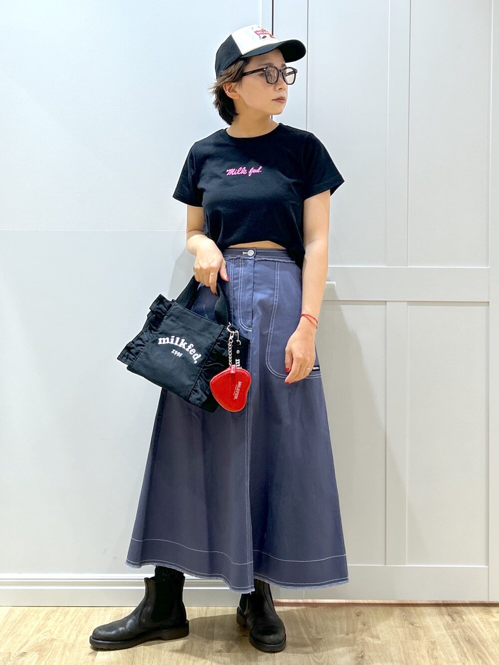 ブルー系のスカート、ブラック系のTシャツ/カットソー、ブラック系のショルダーバッグを着用したレディースの夏コーディネートの3枚目の写真