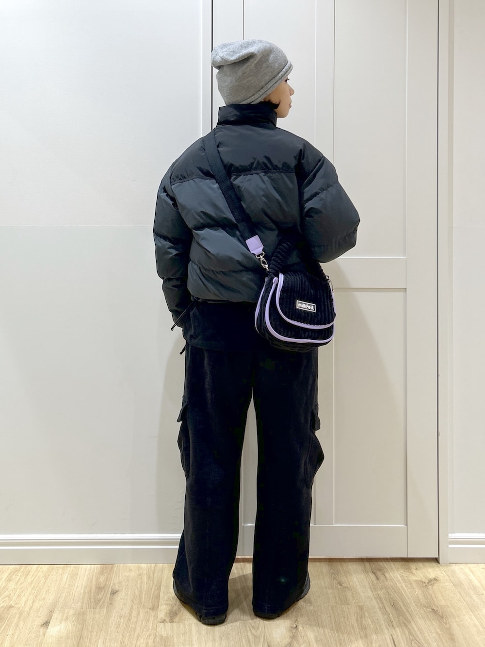 ブラック系のダウンジャケット/コート、ブラック系のTシャツ/カットソー、ブラック系のスウェットパンツを着用したレディースの冬コーディネートの3枚目の写真