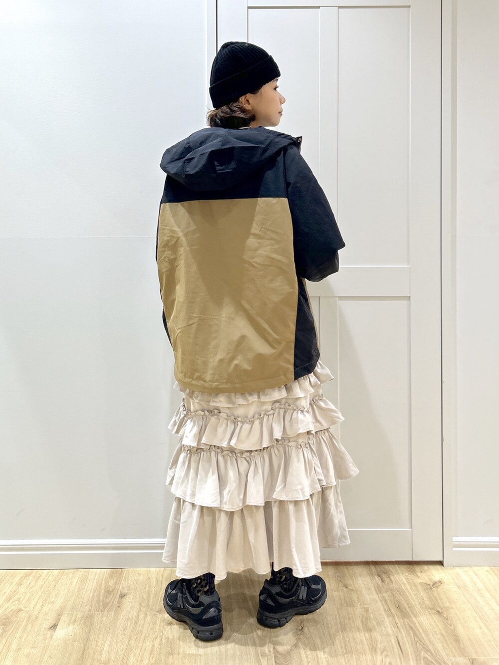 ベージュ系のマウンテンパーカー、ホワイト系のTシャツ/カットソー、ベージュ系のスカートを着用したレディースの秋コーディネートの6枚目の写真