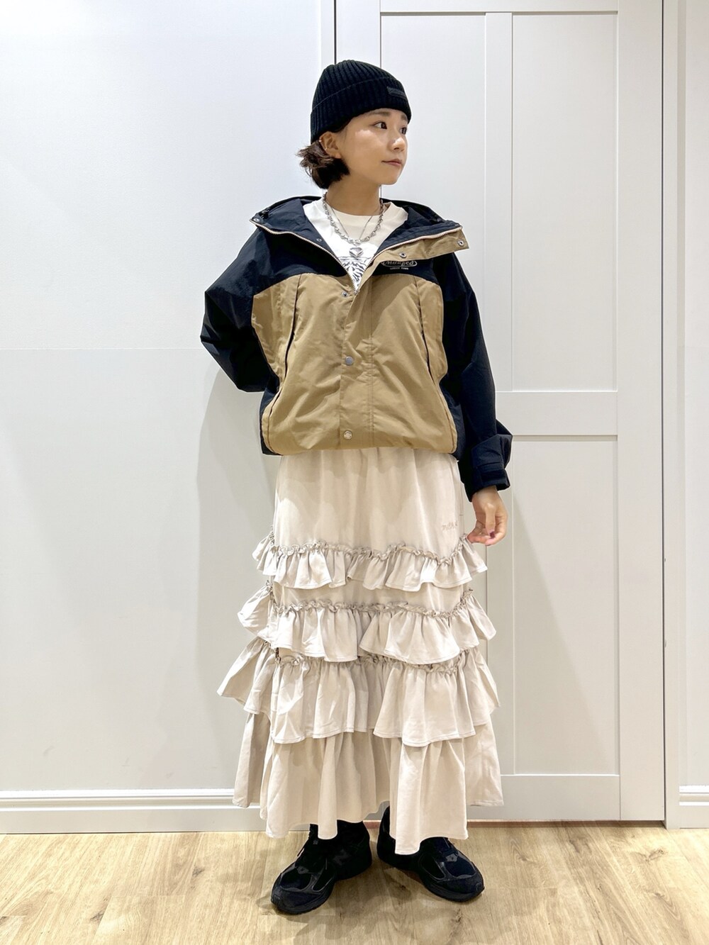 ベージュ系のマウンテンパーカー、ホワイト系のTシャツ/カットソー、ベージュ系のスカートを着用したレディースの秋コーディネートの8枚目の写真