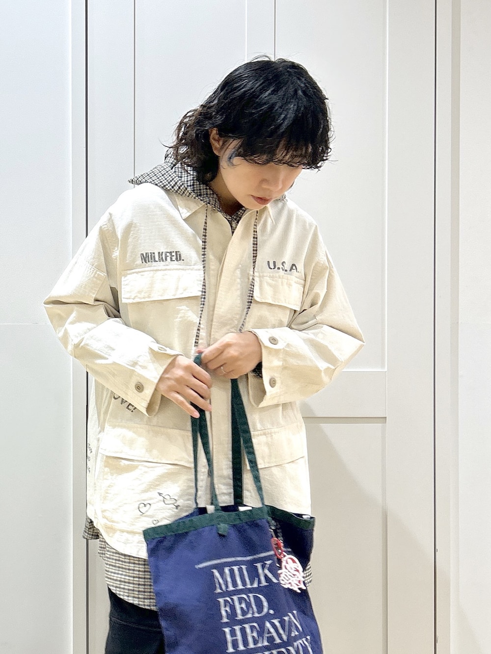 ホワイト系のミリタリージャケット、ベージュ系のシャツ/ブラウス、ブラック系のスウェットパンツを着用したレディースの冬コーディネートの4枚目の写真