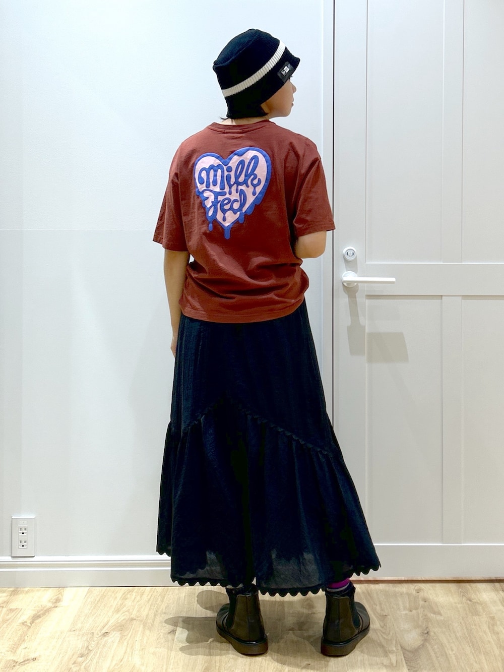 ブラウン系のTシャツ/カットソー、ブラック系のスカート、ブラウン系のトートバッグを着用したレディースの夏コーディネートの5枚目の写真