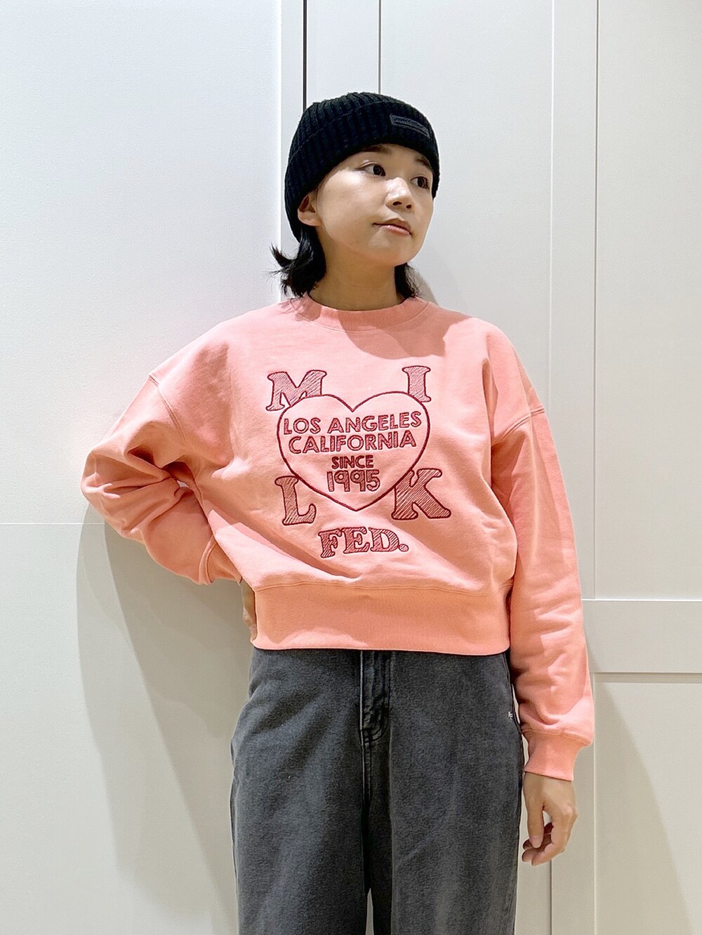 ピンク系のスウェット、ブラック系のデニムパンツ、レッド系のトートバッグを着用したレディースの冬コーディネートの5枚目の写真