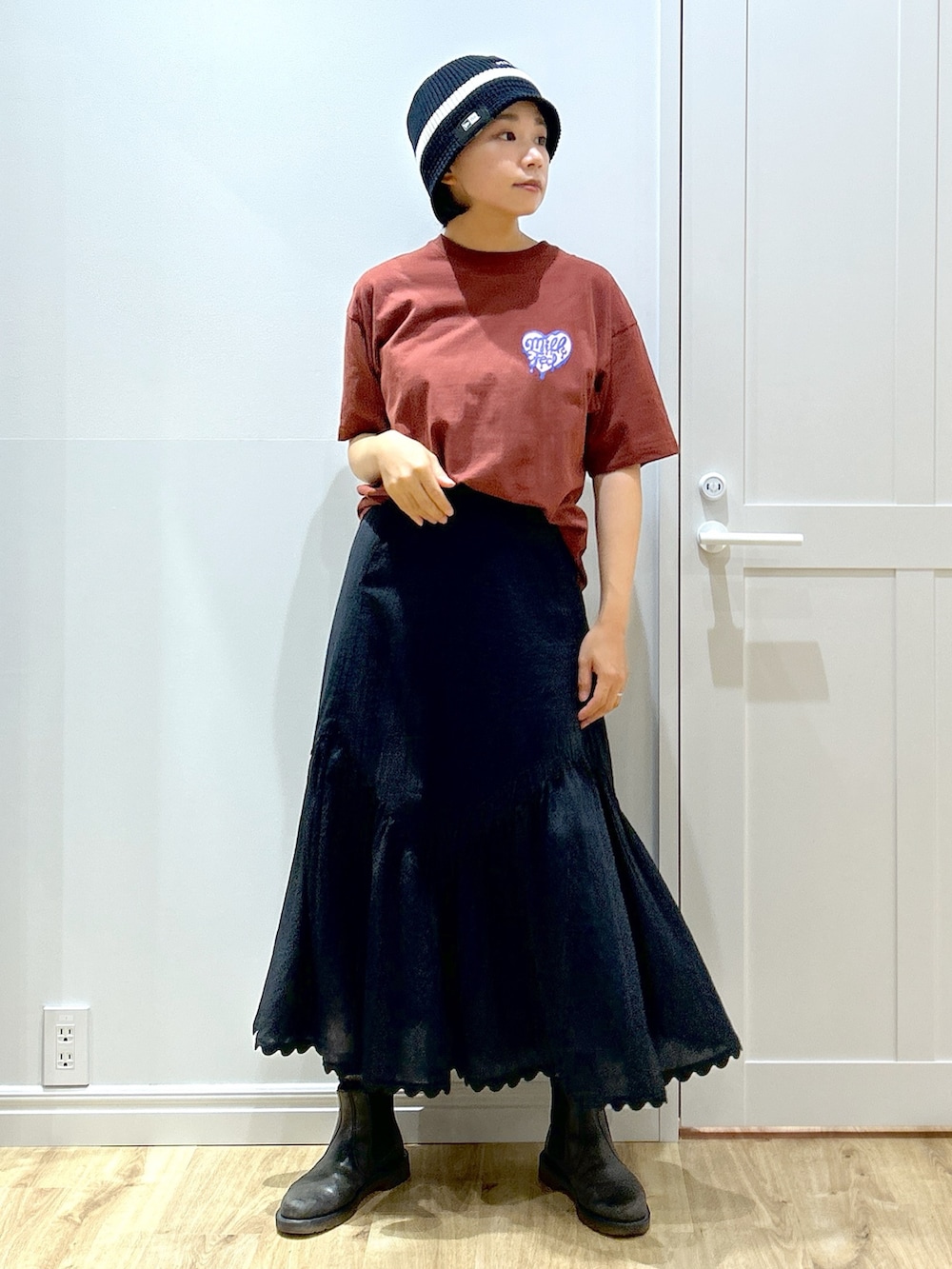 ブラウン系のTシャツ/カットソー、ブラック系のスカート、ブラウン系のトートバッグを着用したレディースの夏コーディネートの4枚目の写真