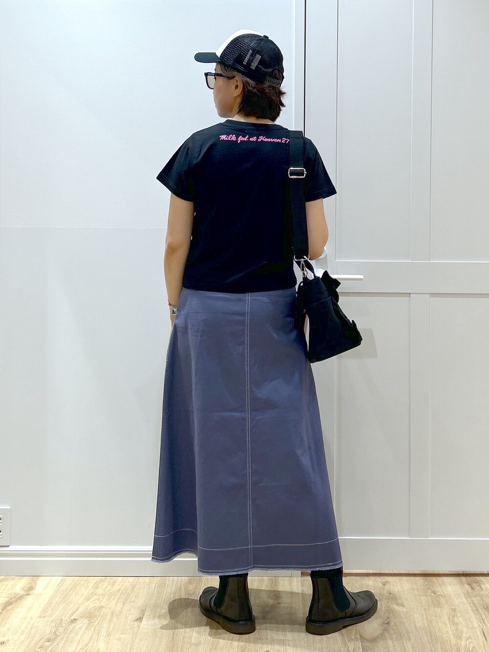 ブルー系のスカート、ブラック系のTシャツ/カットソー、ブラック系のショルダーバッグを着用したレディースの夏コーディネートの2枚目の写真