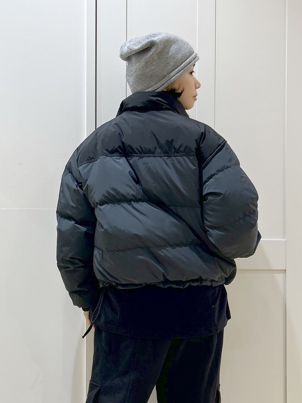 ブラック系のダウンジャケット/コート、ブラック系のTシャツ/カットソー、ブラック系のスウェットパンツを着用したレディースの冬コーディネートの6枚目の写真