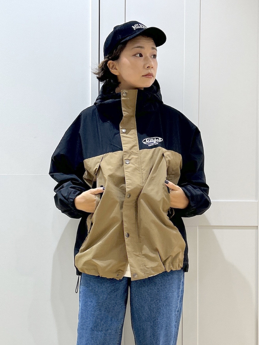 グレー系のTシャツ/カットソー、ベージュ系のマウンテンパーカー、ブルー系のデニムパンツを着用したレディースの秋コーディネートの7枚目の写真