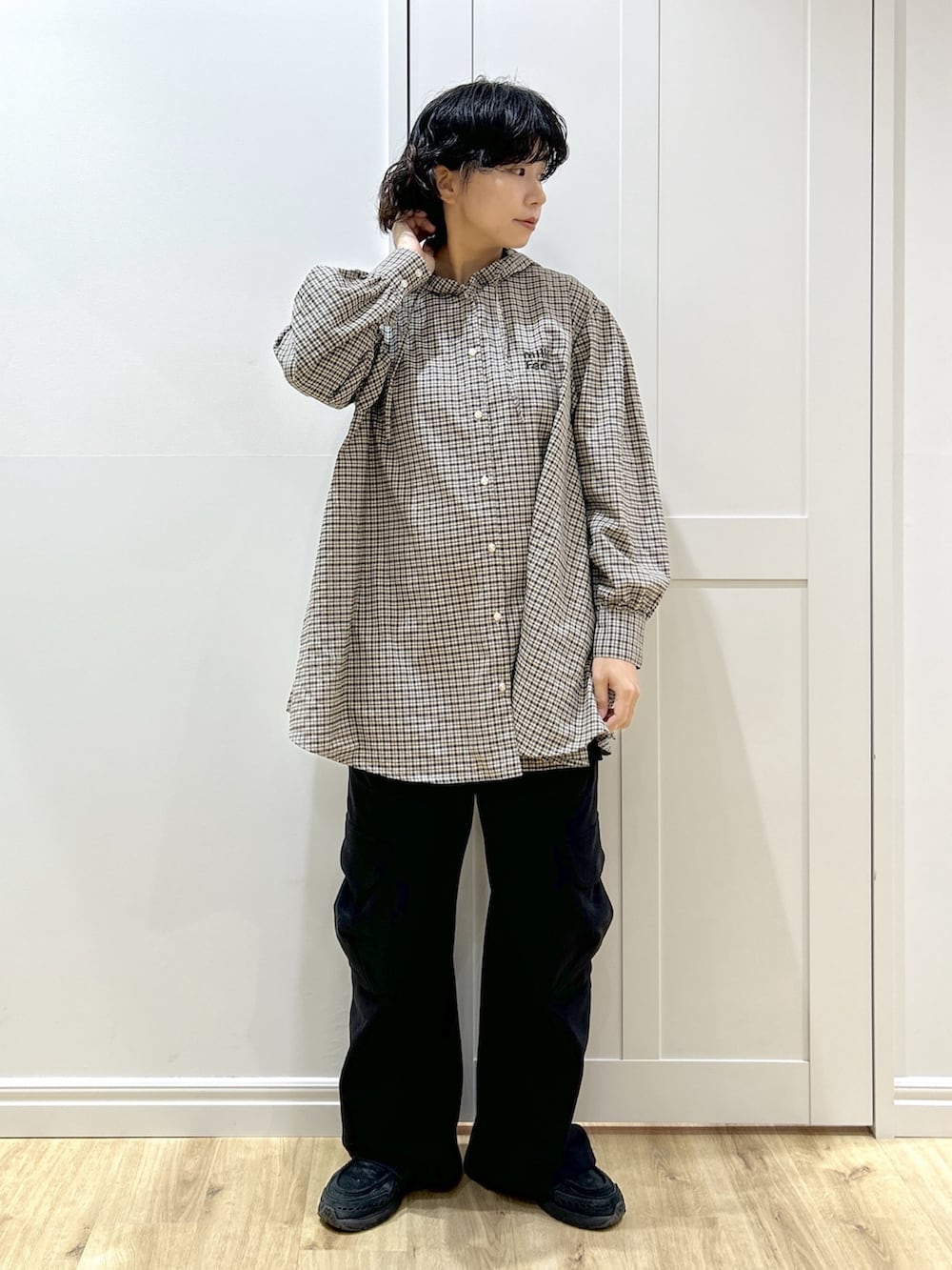 ホワイト系のミリタリージャケット、ベージュ系のシャツ/ブラウス、ブラック系のスウェットパンツを着用したレディースの冬コーディネートの7枚目の写真