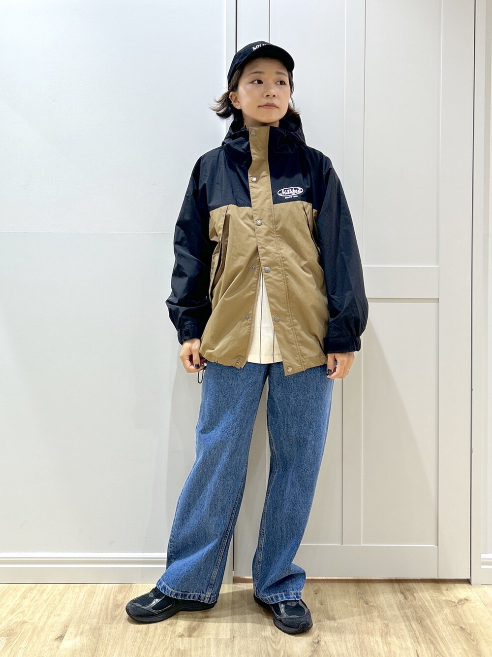 グレー系のTシャツ/カットソー、ベージュ系のマウンテンパーカー、ブルー系のデニムパンツを着用したレディースの秋コーディネートの8枚目の写真