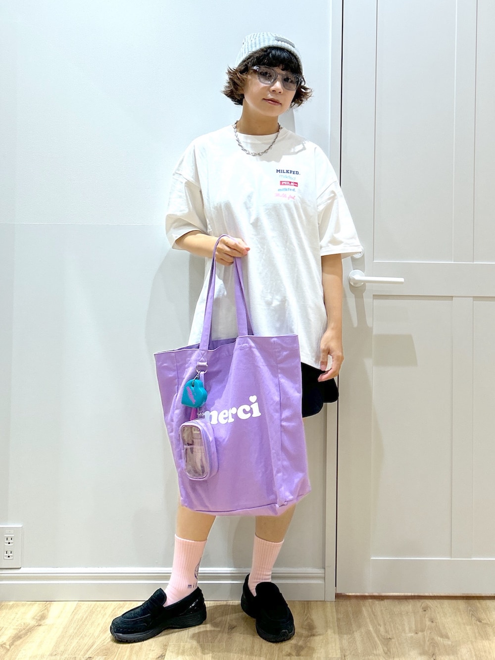 ブラック系のスウェットパンツ、ホワイト系のTシャツ/カットソー、パープル系のトートバッグを着用したレディースの夏コーディネートの2枚目の写真