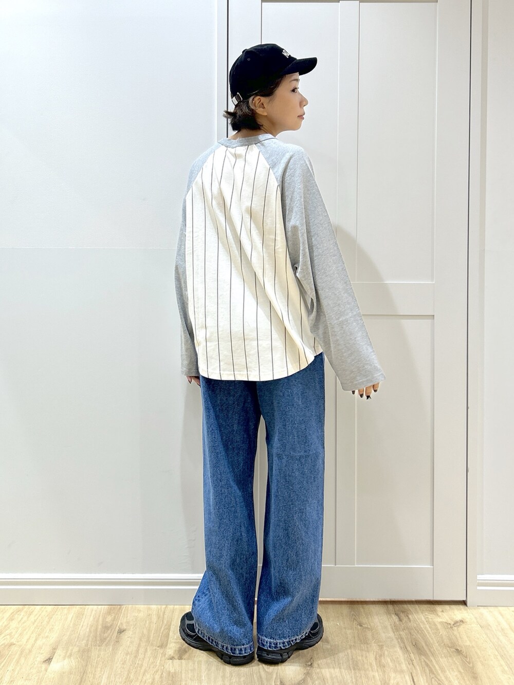 グレー系のTシャツ/カットソー、ベージュ系のマウンテンパーカー、ブルー系のデニムパンツを着用したレディースの秋コーディネートの6枚目の写真