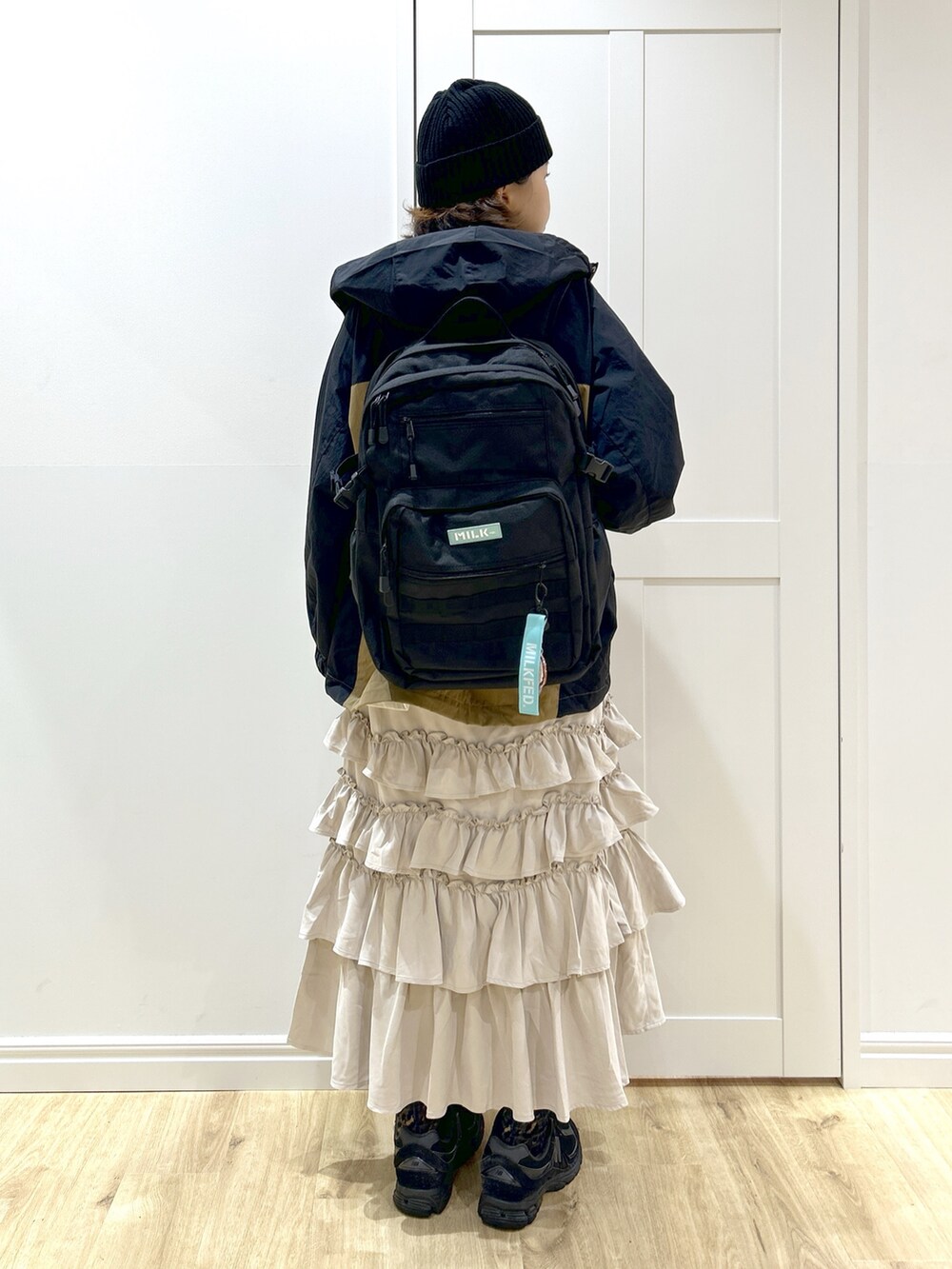 ベージュ系のマウンテンパーカー、ホワイト系のTシャツ/カットソー、ベージュ系のスカートを着用したレディースの秋コーディネートの4枚目の写真