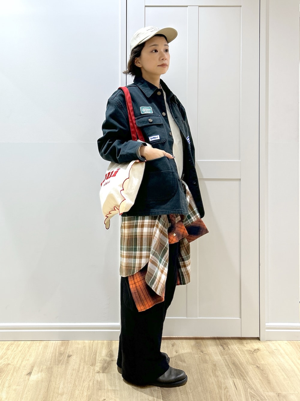 オレンジ系のシャツ/ブラウス、ブラック系のブルゾン、ホワイト系のTシャツ/カットソーを着用したレディースの秋コーディネートの2枚目の写真