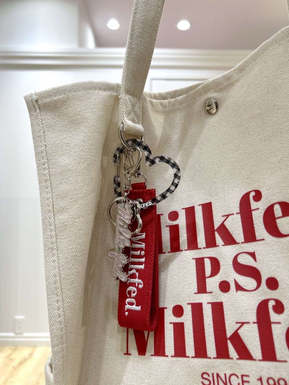 ピンク系のスウェット、ブラック系のデニムパンツ、レッド系のトートバッグを着用したレディースの冬コーディネートの7枚目の写真