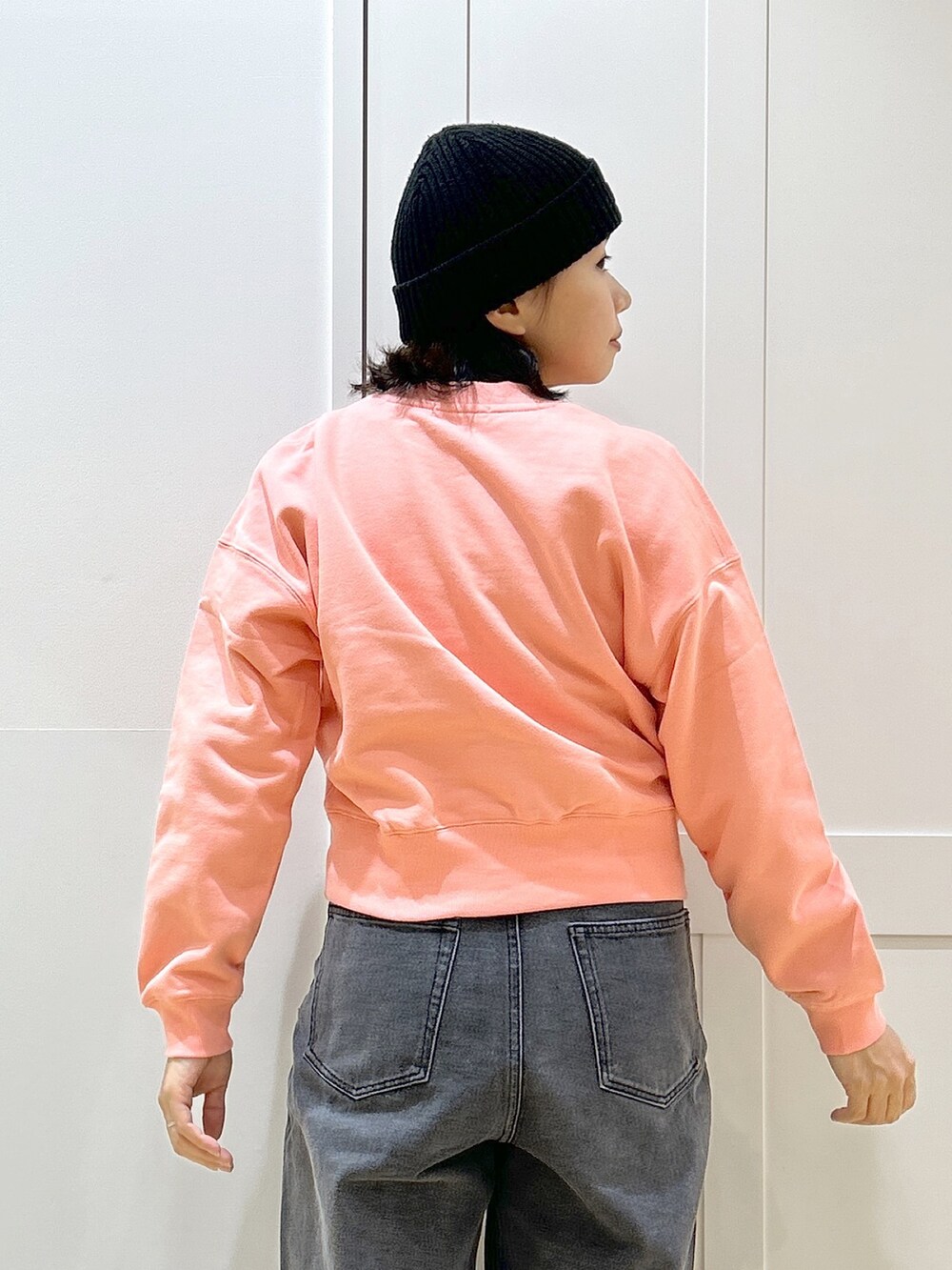 ピンク系のスウェット、ブラック系のデニムパンツ、レッド系のトートバッグを着用したレディースの冬コーディネートの6枚目の写真