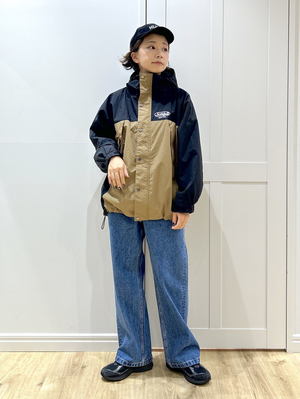 グレー系のTシャツ/カットソー、ベージュ系のマウンテンパーカー、ブルー系のデニムパンツを着用したレディースの秋コーディネートの9枚目の写真