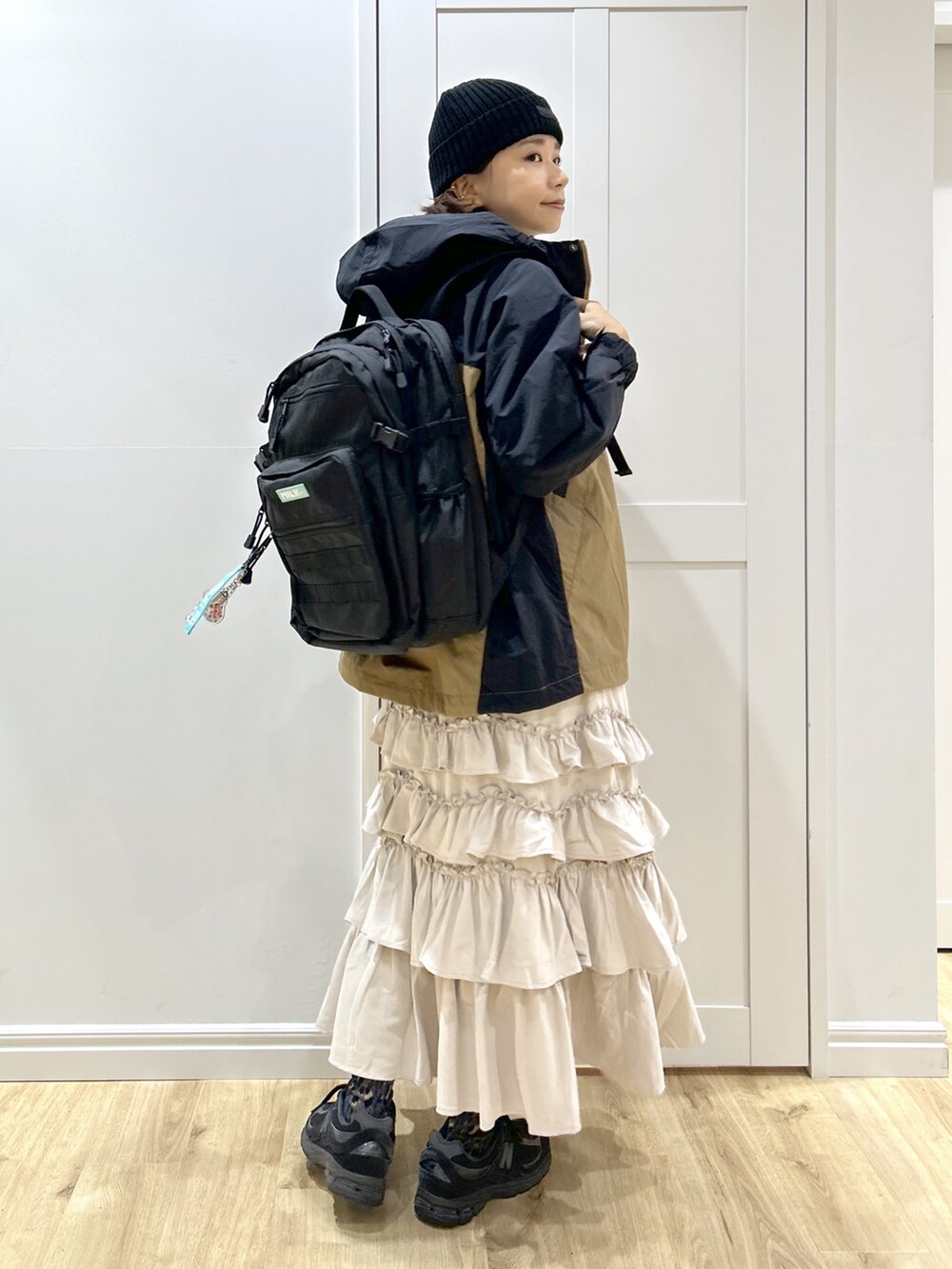 ベージュ系のマウンテンパーカー、ホワイト系のTシャツ/カットソー、ベージュ系のスカートを着用したレディースの秋コーディネートの3枚目の写真