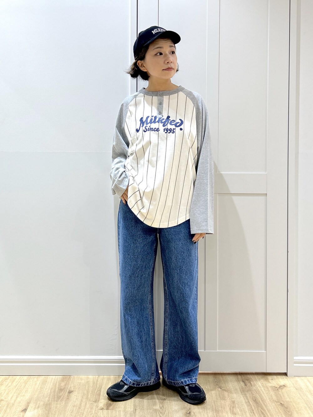 グレー系のTシャツ/カットソー、ベージュ系のマウンテンパーカー、ブルー系のデニムパンツを着用したレディースの秋コーディネートの5枚目の写真