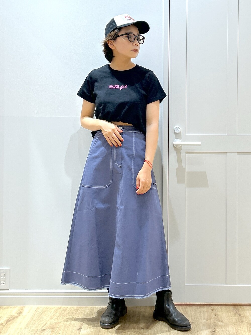 ブルー系のスカート、ブラック系のTシャツ/カットソー、ブラック系のショルダーバッグを着用したレディースの夏コーディネートの4枚目の写真