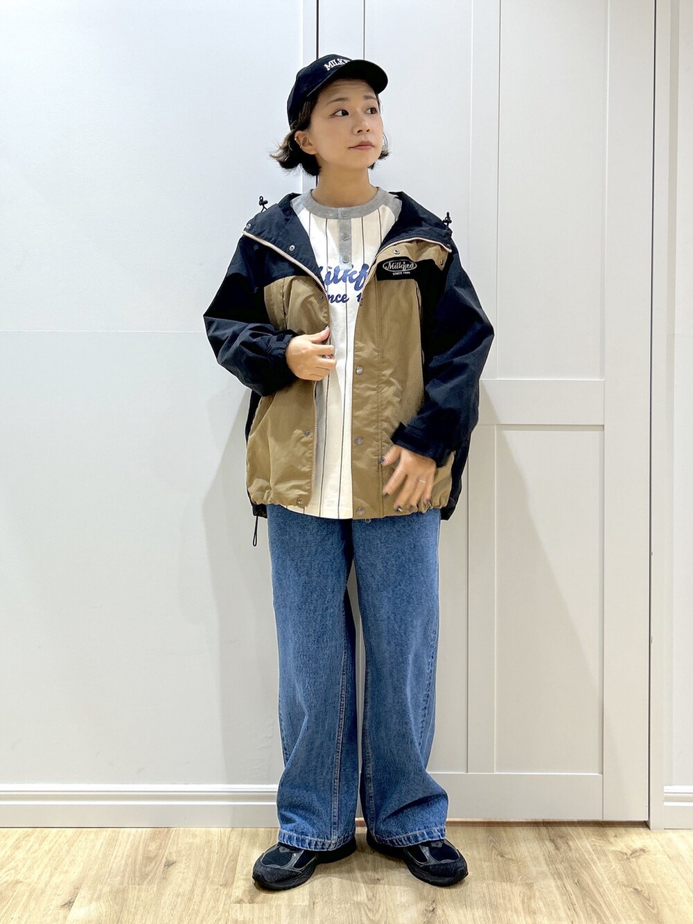 グレー系のTシャツ/カットソー、ベージュ系のマウンテンパーカー、ブルー系のデニムパンツを着用したレディースの秋コーディネートの4枚目の写真