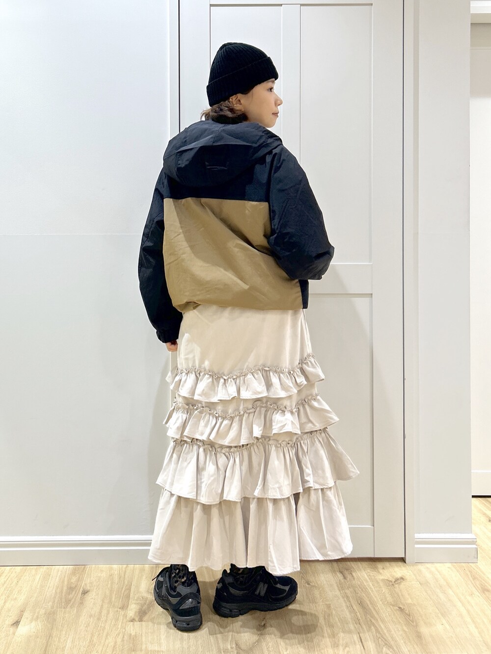 ベージュ系のマウンテンパーカー、ホワイト系のTシャツ/カットソー、ベージュ系のスカートを着用したレディースの秋コーディネートの9枚目の写真