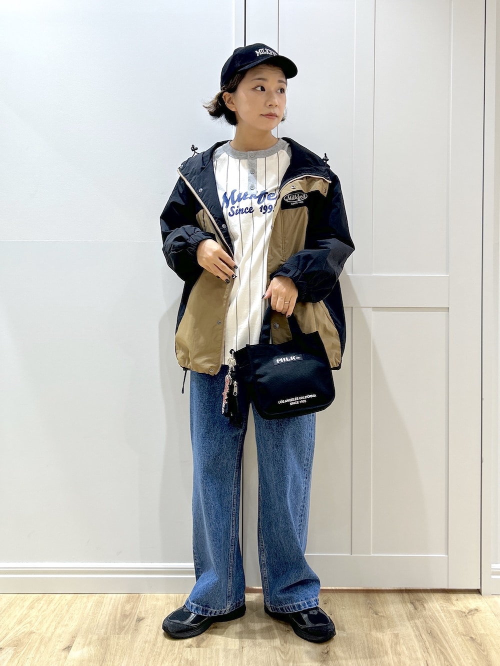 グレー系のTシャツ/カットソー、ベージュ系のマウンテンパーカー、ブルー系のデニムパンツを着用したレディースの秋コーディネートの2枚目の写真