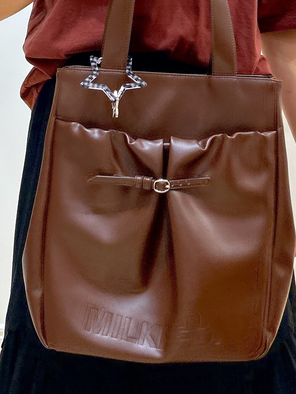 ブラウン系のTシャツ/カットソー、ブラック系のスカート、ブラウン系のトートバッグを着用したレディースの夏コーディネートの6枚目の写真