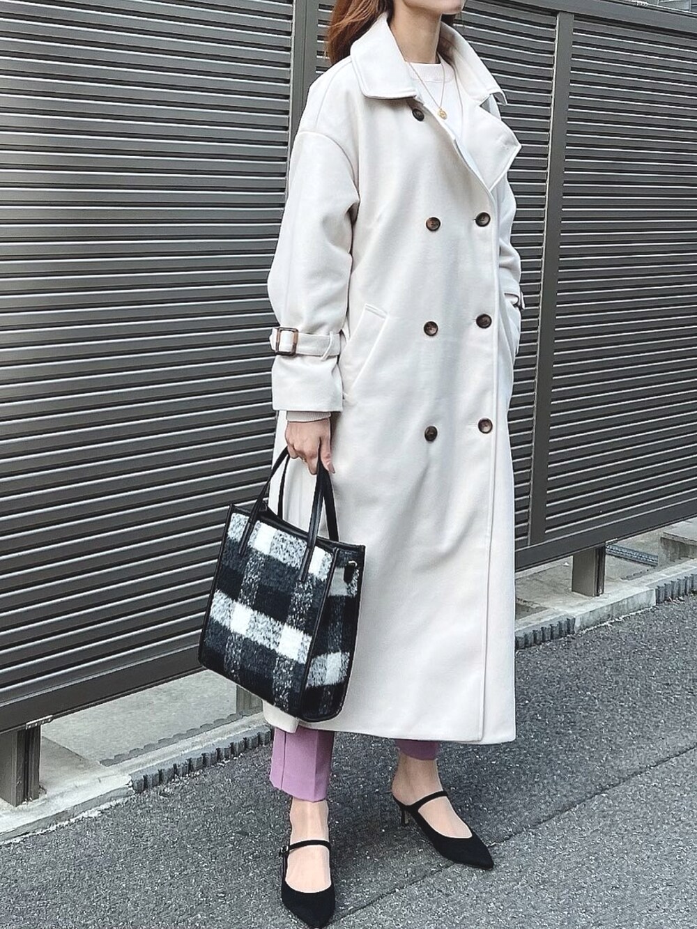 ホワイト系のトレンチコート、ホワイト系のニット/セーター、ブラック系のパンプスを着用したレディースの秋コーディネートの4枚目の写真