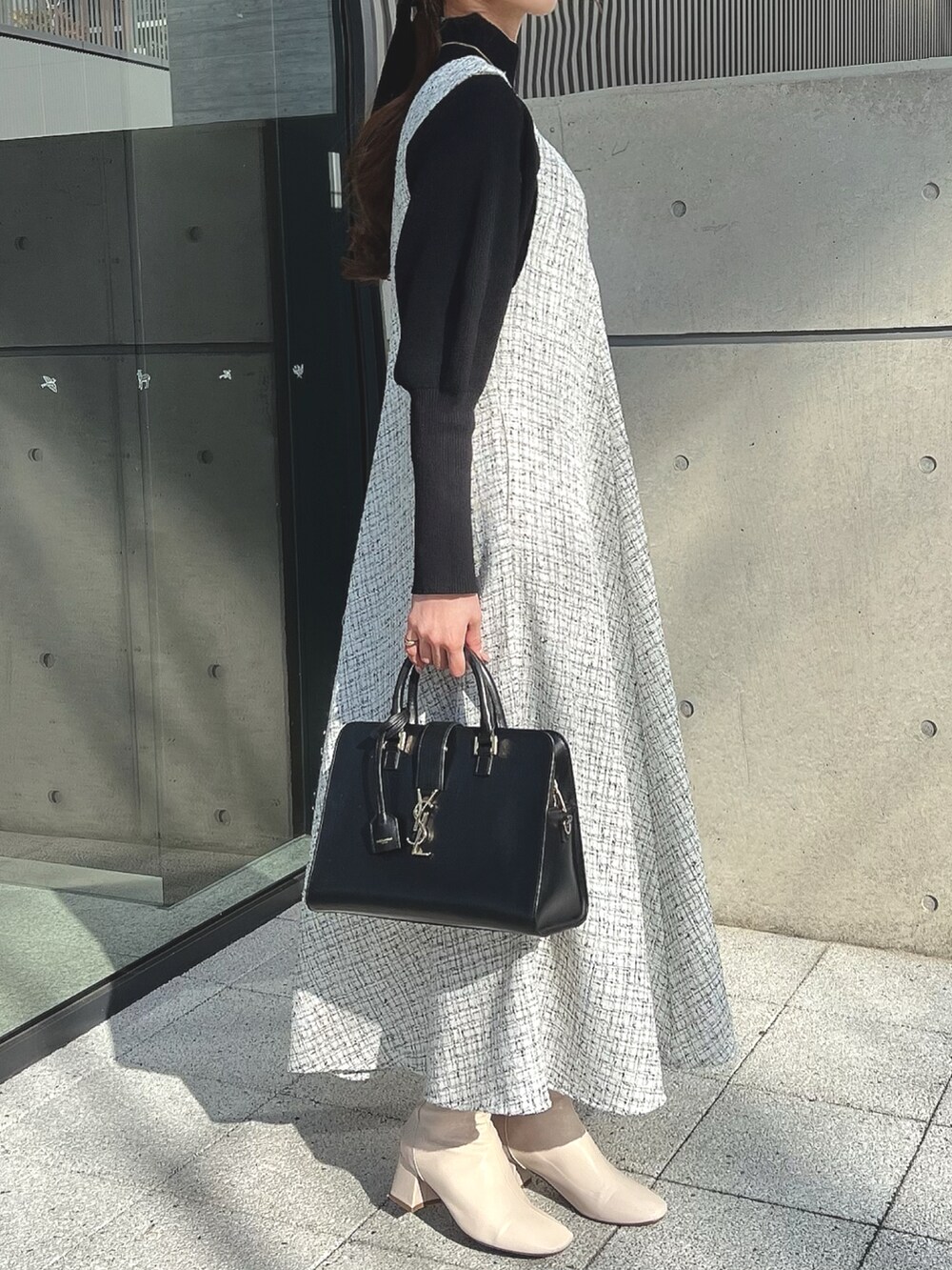 ホワイト系のワンピース、ホワイト系のブーツ、ブラック系のニット/セーターを着用したレディースの冬コーディネートの2枚目の写真