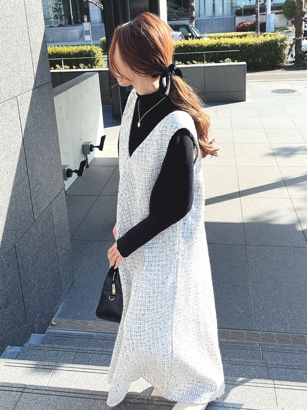 ホワイト系のワンピース、ホワイト系のブーツ、ブラック系のニット/セーターを着用したレディースの冬コーディネートの4枚目の写真