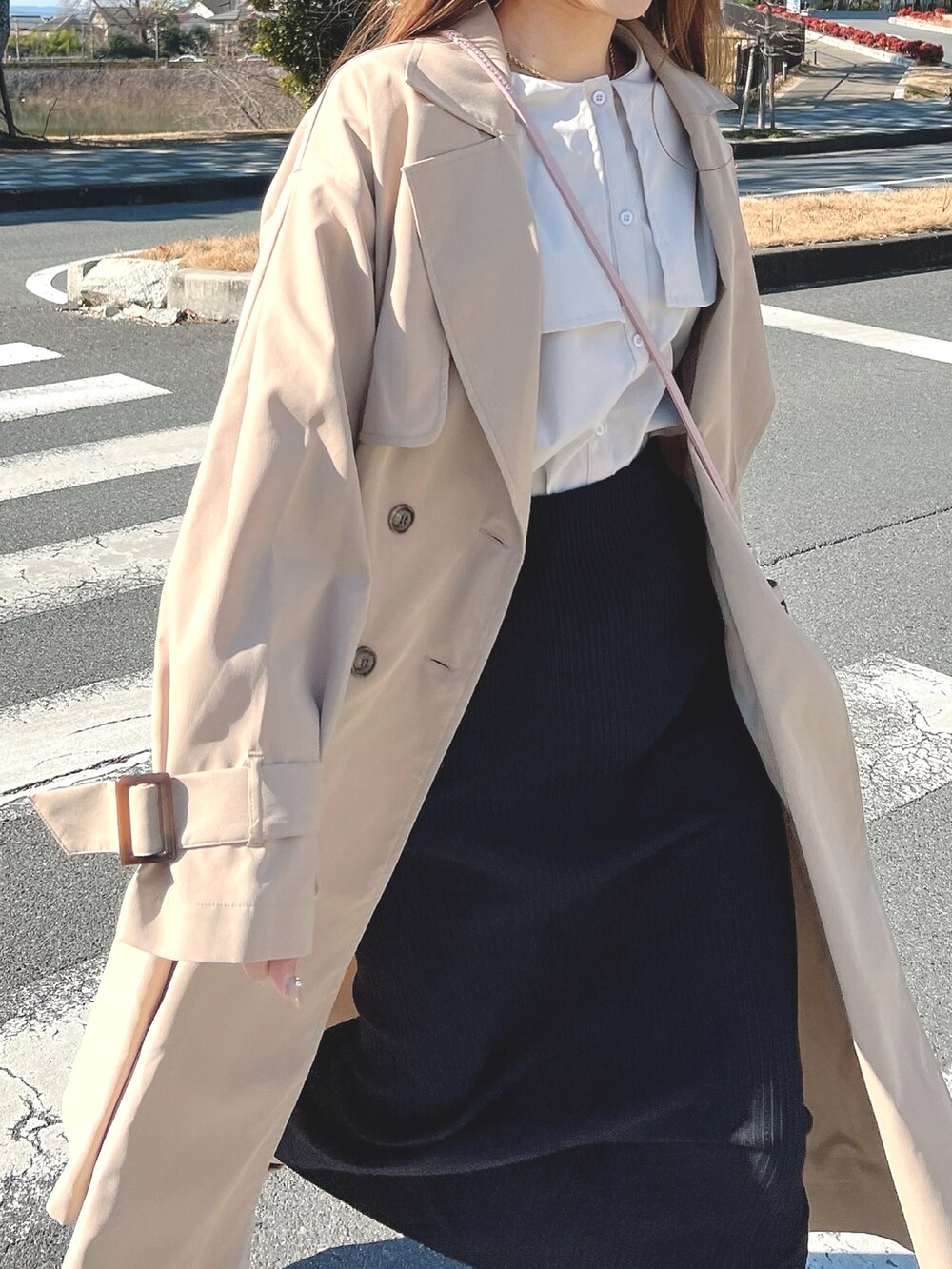 ベージュ系のトレンチコートを着用したレディースの冬コーディネートの3枚目の写真